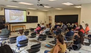 students in desks at seminar taken from behind them