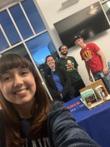 Grad students and postdoc in front of their gingerbread house entry in 2023