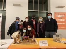 Lab members standing in front of the gingerbread house entry in winter 2021.