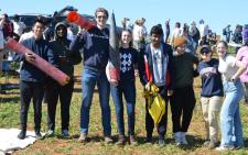 Group of students holding pieces of a rocket