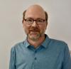 UVA Link Lab Events and Administrative Assistant, Matthew Genson is pictured here in a polo top interior headshot