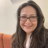 UVA Link Lab Operations Coordinator, Jennifer Burman, pictured here in a blazer and glasses interior headshot.